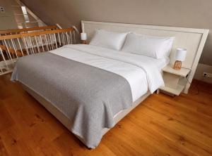 a large white bed with white sheets and pillows at SunCliff Lodge - exklusive private Sauna, Sanarium, Kamin und Meerblick in Dranske