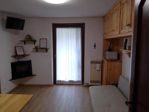 an empty living room with a window and a television at monolocale Sabrina in Torgnon