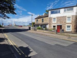 an empty street with a brick building with a red door at Host & Stay - Beachcomber Cottage Apartment in Morecambe
