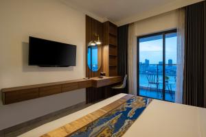 a hotel room with a bed and a tv and a window at M9 Kirirom Hotel in Phnom Penh