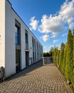 a white building with a brick walkway at Edel Wellness Sleep & Spa in Gniezno
