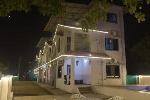 a white building with lights on it at night at Coastal Gateway Resort in Revadanda