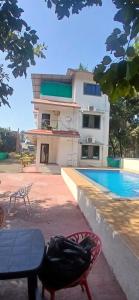 a bird sitting on a chair in front of a house at Coastal Gateway Resort in Revadanda