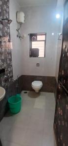 a bathroom with a toilet and a sink and a window at Coastal Gateway Resort in Revadanda
