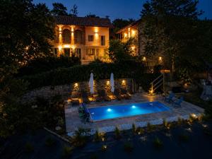 a house with a swimming pool at night at La Vita è Bella in Somano