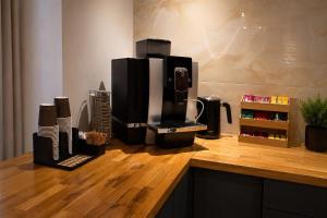 a coffee maker sitting on top of a wooden counter at Edel Wellness Sleep & Spa in Gniezno