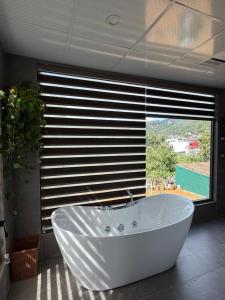 a white bath tub in a bathroom with a window at Sun Hill Villa in Lao Cai