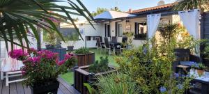 a garden with flowers and plants on a house at Le résinier in Mimizan