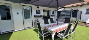 a table and chairs with an umbrella on a lawn at Le résinier in Mimizan +28 photos