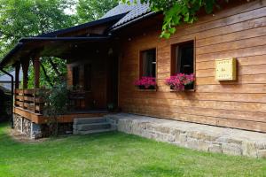 a house with flowers on the side of it at Pod Dzwonkiem in Jasienica
