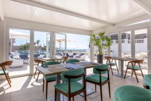 a restaurant with tables and chairs and a view of the ocean at Ona el Marqués in Puerto de Santiago