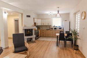 a kitchen with a table and chairs and a fireplace at Przystań Hartowiec in Ostaszewo +36 photos