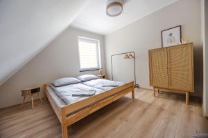 a bedroom with a bed and a wooden floor at Przystań Hartowiec in Ostaszewo