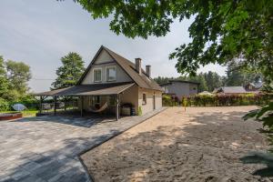 a house with a gambrel roof and a playground at Przystań Hartowiec in Ostaszewo