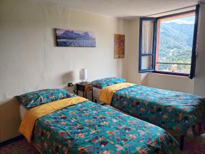a room with two beds and a window at La Dimora di Beatrice in Santa Brigida