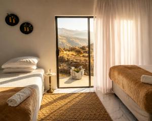 a bedroom with two beds and a window with a view at 1010 On The Edge in Mokhotlong