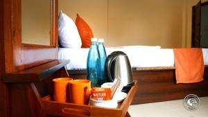 a wooden tray with cups and bottles in a bedroom at Eagles Hideout Kandy in Bowala
