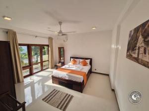 a bedroom with a bed and a large window at Eagles Hideout Kandy in Bowala