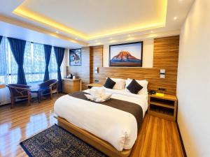 a hotel room with a large bed and a desk at The Potola Hotel And Restaurant With Parking Facility in Darjeeling