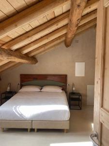 a bedroom with a large bed with wooden ceilings at DIMORA STORICA ZACCHI D'ARRIGO in Belluno