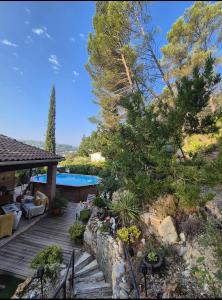 a backyard with a wooden deck and a swimming pool at La Parenthèse Provençale in Cabasse
