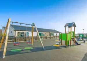 an empty playground with swings and a slide at Sunset View - with view of the lighthouse and a shower and bath in Lossiemouth