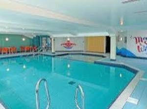 a large swimming pool in a hotel room at Sunset View - with view of the lighthouse and a shower and bath in Lossiemouth
