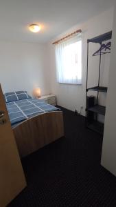a bedroom with a bed with blue sheets and a window at Gästehaus mit 3 separaten Schlafbereichen, Terrasse und Carport in Velten