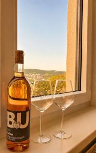 a bottle of whisky and two wine glasses on a window at Haus Johannes in Braubach