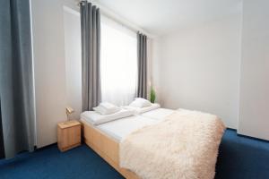 a bedroom with a bed with white sheets and a window at Sami Swoi Kutno in Kutno