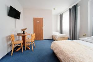 a hotel room with a bed and a table and chairs at Sami Swoi Kutno in Kutno
