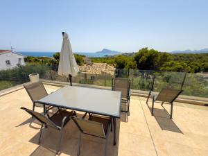 a table with chairs and an umbrella on a patio at Cyclolodge in Altea
