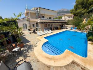 a swimming pool in front of a house at Cyclolodge in Altea