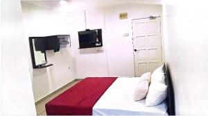 a bedroom with a bed with a red blanket and a tv at Hotel Lii View in Mersing