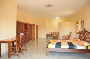 a bedroom with a bed and a table and chairs at Green Garden Lodge in Nosy Be