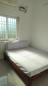 a large bed in a room with a window at Sai Residency in Pallineriyanur