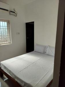 a large white bed in a room with a window at Sai Residency in Pallineriyanur +4 photos