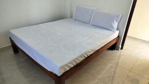 a bed with a blue pillow on top of it at Sai Residency in Pallineriyanur