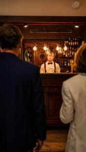 a man standing at a bar in front of a mirror at Stara Szkoła Boutique Hotel in Wronki