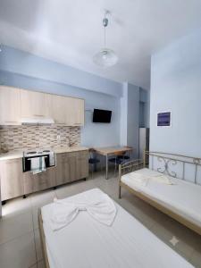 a room with two beds and a kitchen with a table at Studio Beleri in Himare
