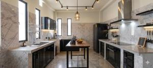 a large kitchen with a counter and a table in it at Hangar pista36 in Hacienda Santa Rosa