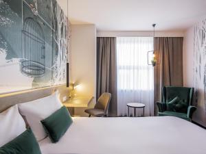 a hotel room with a bed and a chair at ibis Styles Kraków East in Krakow