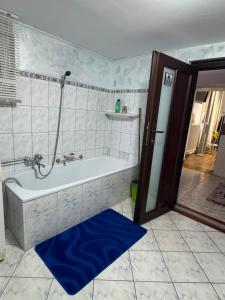 a bathroom with a tub and a blue rug at Casa Lucescu in Vatra Dornei +27 photos