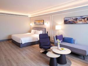 a hotel room with a bed and a table and a couch at Mercure Xi'an Qujiang in Xi'an +154 photos