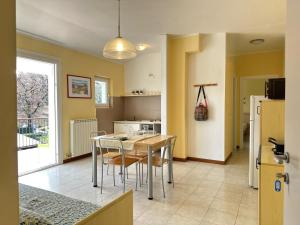 a kitchen and dining room with a table and chairs at Bran & Denise Residence in Costermano