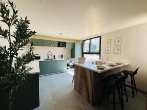 a kitchen with a large island with bar stools at 6 Suites Signature in Saint-Jacques-de-la-Lande