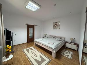 a white bedroom with a bed and a window at Casa Lucescu in Vatra Dornei