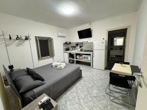 a bedroom with a bed and a table and a kitchen at Eden Affittacamere in Anzio