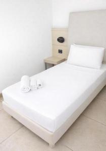 a white bed with two towels on top of it at HOTEL HMR RHO Milano in Rho