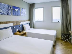 two beds in a room with two windows at ibis Styles Confins Aeroporto in Lagoa Santa +143 photos